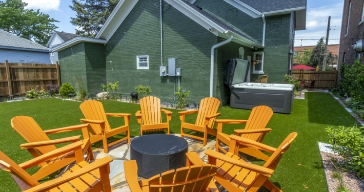 Backyard fire pit with Adirondack chairs and hot tub at a Northwest Indiana vacation home