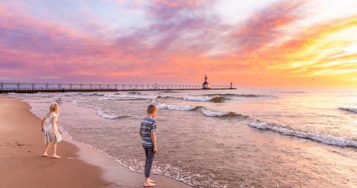 Sunset over Lake Michigan beach with Michigan City lighthouse pier